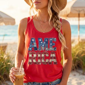 Könnte beinhalten: Ein rotes ärmelloses Tanktop mit dem Wort AMERICA in großen Blockbuchstaben. Die Buchstaben A, M und E sind mit einem blauen Jeansmuster mit weißen Sternen gefüllt, während die Buchstaben R, I, C und A ein rot-weiß gestreiftes Muster aufweisen.