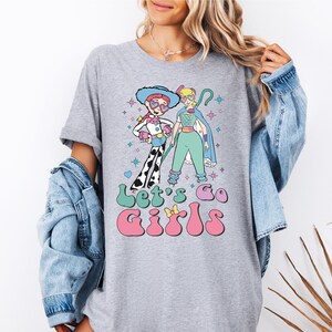 a woman wearing a t - shirt with a cartoon character on it