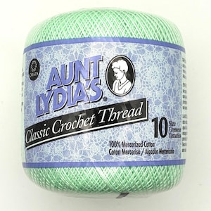 May include: A ball of light green Aunt Lydia's Classic Crochet Thread, size 10, made of 100% mercerized cotton. The label features the brand name, a circular illustration of a person, and the text 100% Mercerized Cotton, Coton Mercerisé, Algodón Mercerizado.