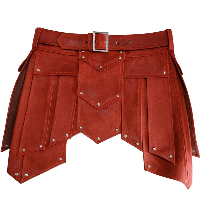 Puede incluir: Un kilt de cuero rojo con cintur&oacute;n y hebilla. El kilt presenta paneles decorativos con remaches plateados y un dise&ntilde;o &uacute;nico en capas. El cintur&oacute;n tiene una hebilla plateada y se asegura con remaches. Una prenda llamativa.