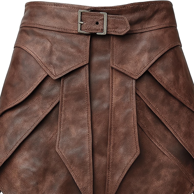 May include: A brown leather skirt with a unique layered design. The skirt features a belt with a silver buckle. The leather has a textured appearance, and the skirt has a distinctive, geometric shape.