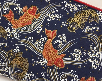 May include: Navy blue fabric with a repeating pattern of red and gold koi fish swimming among white and gold waves. The koi have detailed scales and fins. The design has a Japanese aesthetic.