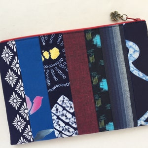 May include: A blue and red patchwork zippered pouch with a variety of Japanese fabric patterns.