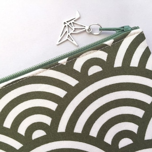 May include: A green zippered pouch with a white and green geometric pattern. The zipper pull is a silver origami crane.