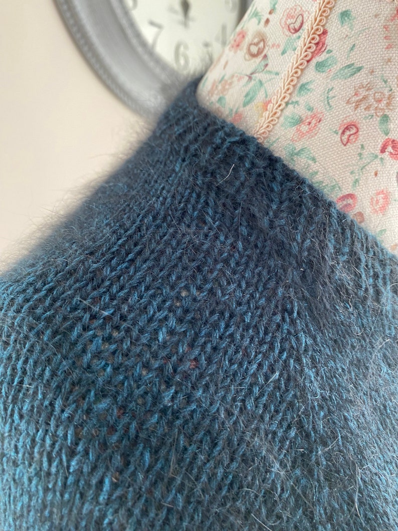 May include: A dark blue knitted sweater with a fuzzy texture.