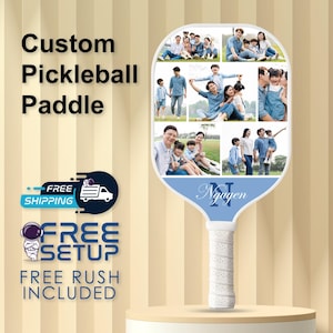 May include: A custom pickleball paddle with a white grip and a blue and white paddle face. The paddle face features a collage of family photos and the name "Nguyen" in script. The text "Custom Pickleball Paddle" is displayed in black.
