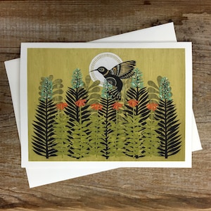 May include: A black hummingbird with white and blue accents flies over a field of green and black ferns with red flowers. The background is a light yellow with a white circle.