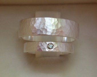 グリーンまたはホワイトサファイアの宝石がちりばめられたハンマー加工の結婚指輪。男性用と女性用の、純銀製の手作り結婚指輪。