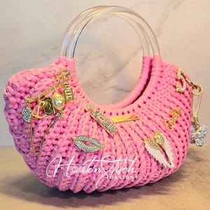 Bolso de mano con asa superior de acrílico rosa y colgante de crochet