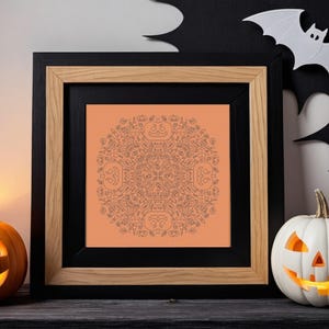 May include: A framed print with a black and orange colour scheme. The print features a circular design with a Halloween theme. The design is made up of various Halloween symbols, including pumpkins, bats, and ghosts. The print is surrounded by a black frame with a wood-toned outer frame.