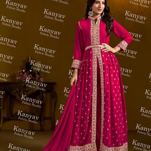 Pode incluir: Um vestido de noite magenta com bordados dourados. O vestido de manga comprida tem gola alta, cintura cintada e saia fluida. O vestido inclui um xale a condizer, ideal para ocasi&otilde;es especiais.