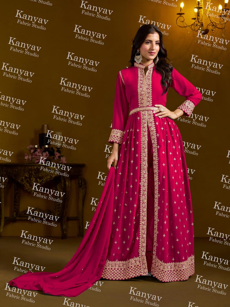 Pode incluir: Um vestido de noite magenta com bordados dourados. O vestido de manga comprida tem gola alta, cintura cintada e saia fluida. O vestido inclui um xale a condizer, ideal para ocasi&otilde;es especiais.