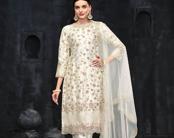 May include: Ivory-colored embroidered salwar kameez ensemble. The outfit includes a long-sleeved tunic, matching pants, and a sheer dupatta. The floral embroidery is in shades of gold and brown. The text "D.NO.:- 2411" is visible.