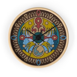 May include: Round wall clock with a light wood frame and a colorful, stylized design. The clock face features a central emblem with red, yellow, blue, and green elements, surrounded by a dark wood-grain border. Black clock hands indicate the time.