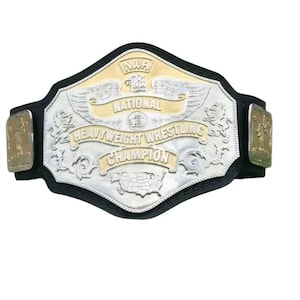 May include: A wrestling championship belt with a silver and gold design. The belt features the text "NWA NATIONAL HEAVYWEIGHT WRESTLING CHAMPION" and an eagle emblem. The belt is black with gold side plates.