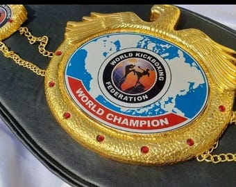 Op de afbeelding: Een goudkleurige World Kickboxing Federation kampioenschapsriem. De riem heeft een centraal embleem met een wereldkaartontwerp en de woorden "World Kickboxing Federation" en "World Champion".