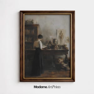 May include: A framed vintage print depicts a woman reading at a desk in a study. The artwork features a dark wooden frame with a gold inner edge. The scene includes a bookshelf, anatomical drawings, and a microscope. The text "Madame Art Prints" is at the bottom.