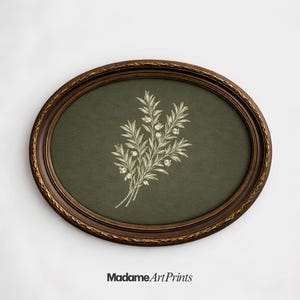May include: An oval framed print featuring a botanical illustration of a floral bouquet. The artwork is set against a dark green background and framed in a dark brown, ornate frame. The text "Madame Art Prints" is at the bottom.