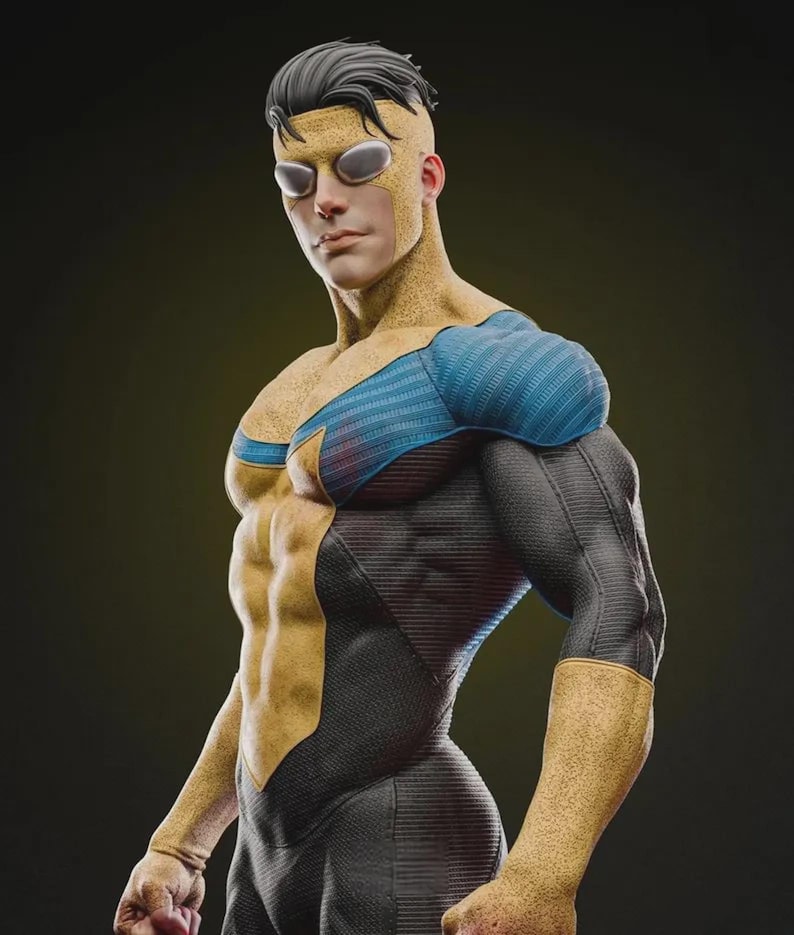 Puede incluir: Una figura de superh&eacute;roe con un traje amarillo y negro con detalles azules. El personaje lleva una m&aacute;scara con lentes transparentes y un peinado distintivo. El traje tiene una apariencia texturizada, y la figura posa con una expresi&oacute;n segura.