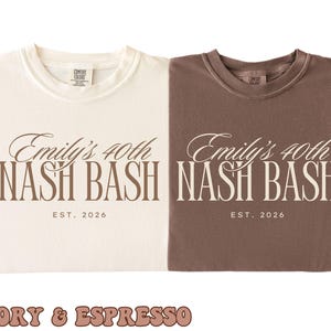 Op de afbeelding: Twee T-shirts met ronde hals in ivoor en espressobruin. Het ivoorkleurige shirt heeft donkerbruine tekst met Emily's 40th NASH BASH EST. 2026. Het espressokleurige shirt heeft ivoorkleurige tekst met Emily's 40th NASH BASH EST. 2026. Beide shirts hebben een label.