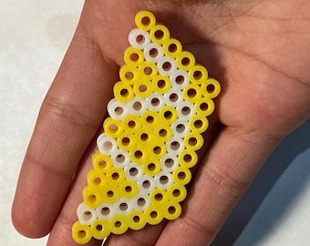 May include: A yellow and white bead lemon design, made with small round beads, held in a hand.