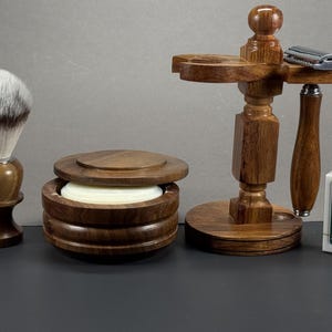 Puede incluir: Un set de afeitado que incluye una brocha de madera con cerdas blancas, un cuenco de madera para jabón con tapa, un soporte de madera con una maquinilla de afeitar de metal y una pequeña caja blanca de cuchillas Derby Extra Super Stainless.
