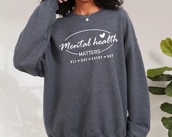 May include: A dark gray sweatshirt with the text "Mental health matters" in a white circle with a heart above the text and the words "All day every day" below the circle.