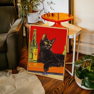 Puede incluir: Un p&oacute;ster vintage enmarcado con un gato negro sentado en una barra con dos botellas de cerveza. El p&oacute;ster tiene un fondo rojo con acentos amarillos y naranjas.