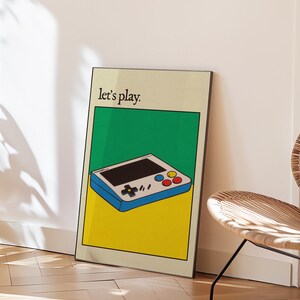 May include: A retro-style video game console with a blue and white design, yellow and green background, and the text "Let's play."