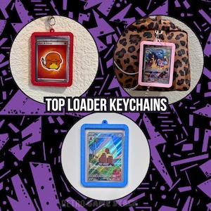May include: Three top loader keychains featuring rectangular frames in red, light pink, and blue. Each frame holds a collectible trading card. The red frame contains a fire energy card, the pink frame a character card, and the blue frame a landscape card.
