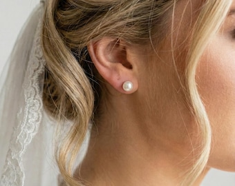 Peut inclure: Une boucle d'oreille à puce composée d'une perle blanche ronde portée au lobe de l'oreille. La perle présente une surface lisse et lustrée ainsi qu'une forme sphérique classique, offrant une esthétique simple et épurée pour l'oreille.
