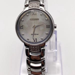 Vintage des années 2000 CITIZEN ECO-DRIVE nacre sunburst avec une carte du monde cadran argenté et diamants montre-bracelet à quartz pour femme