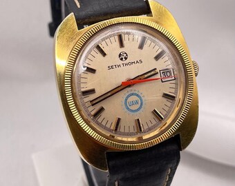 Reloj de vestir unisex vintage de SETH THOMAS de la década de 1960: caja tipo cojín chapada en oro, automático, correa de cuero negro.