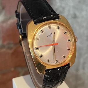 Orologio unisex vintage svizzero degli anni '70 con cassa placcata in oro EDOX, 17 rubini, carica manuale, lancetta dei secondi rossa e cinturino in pelle nera.