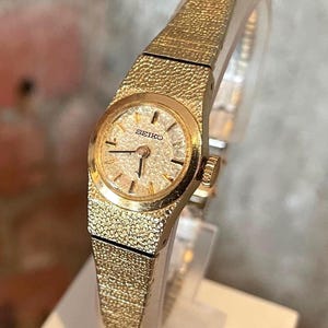 Vintage Dainty 1970s Seiko Gold Plated Round Case Gold &quot;Pebble&quot; Dial Ladies 17 Jewel Wind Up Wristwatch With Gold Plated Bracelet Strap
