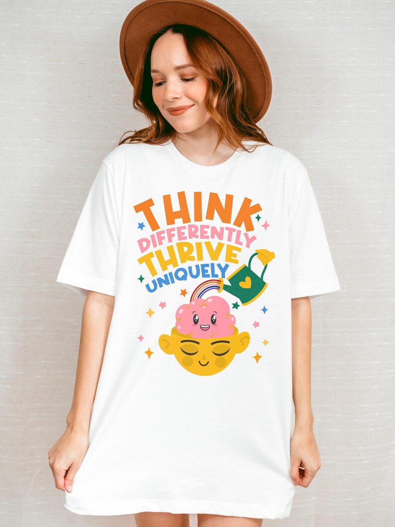 Autism Shirt with a positive message: 'Think Differently, Thrive Uniquely.' This Autism Awareness Shirt features a colorful design with a smiling brain, rainbow, and watering can, symbolizing growth and neurodiversity. Perfect as an Autism Teacher Shirt, Neurodivergent Shirt, ADHD Shirt, Anxiety Shirt, or ABA Therapist Shirt to promote inclusivity and self-expression