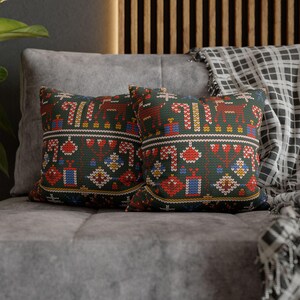 May include: Two decorative throw pillows with a green background and a colorful geometric pattern. The pillows are made of a soft, textured fabric and feature a festive design.
