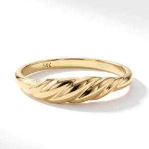 May include: A polished 14K yellow gold ring featuring a twisted, rope-like texture across the top half of the band. The interior of the band is clearly stamped with the text 14K, indicating the gold purity of this solid metal jewellery piece.