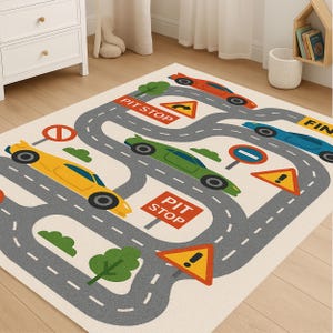 カラフルな道路、ピットストップ、車両が描かれたレーストラックカーラグ。車、スピード、レース、冒険が大好きなお子様のための楽しいプレイルームカーペットです。