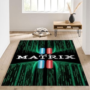 Peut inclure: Un tapis de sol noir et vert avec les mots "The Matrix" en blanc. Le tapis a un motif de lignes vertes et deux pilules, une bleue et une rouge.