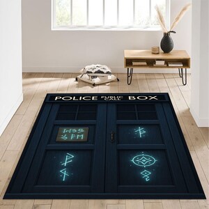 Könnte beinhalten: Ein rechteckiger blauer Teppich mit dem ikonischen Design der Police Public Call Box. Der Teppich hat einen Used-Look, mit den Worten "POLICE PUBLIC CALL BOX" oben. Die Tür hat ein kleines Schild mit der Aufschrift "1:35 PM" und leuchtenden blauen Symbolen.