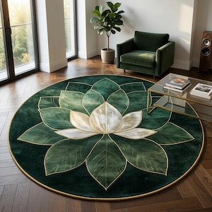 May include: A round, dark green rug with a large lotus flower design. The flower's petals are in shades of green and white, outlined with gold. The rug is placed on a wooden floor, with a green armchair and a glass coffee table in the background.