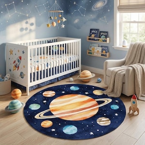 May include: A nursery with a space theme. A white crib with rocket and planet decals sits next to a round rug with a planet design. A mobile with planets hangs above the crib. The walls are painted blue with a galaxy mural.