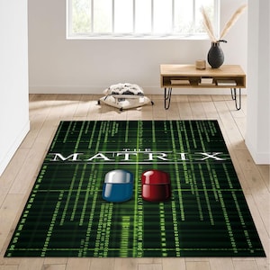 Peut inclure: Tapis de sol vert et noir avec les mots "The Matrix" en blanc. Le tapis a un motif numérique avec deux pilules, une rouge et une bleue, au centre.