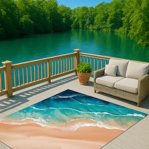 Könnte beinhalten: Ein rechteckiger Outdoor-Teppich mit einer Strandszene. Der Teppich zeigt einen Sandstrand, türkisfarbene Wellen und einen tiefblauen Ozean. Der Teppich liegt auf einer Holzterrasse mit einem Korbmöbel und einer Topfpflanze.