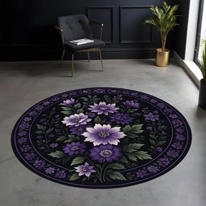 May include: Circular rug with a black base, adorned with a central design of large purple and white flowers. The rug's border is dark purple, with smaller purple flowers and green foliage. The rug is on a grey floor.