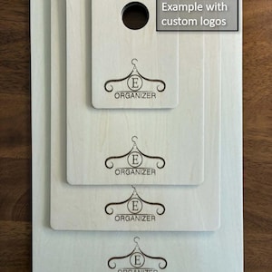 May include: Four light-coloured wooden organiser boards stacked together, each with a hanger logo and the word "ORGANISER". The top board has a hole. Text in the top right corner reads "Example with custom logos".