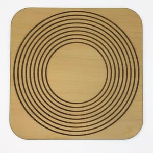 May include: A square wooden coaster with a concentric circle design. The coaster is made of light brown wood and has a natural finish.