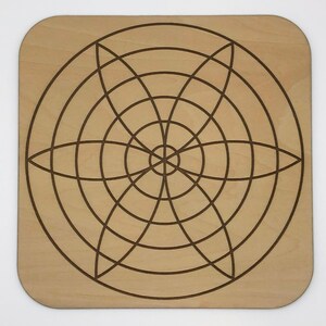 May include: A wooden square board with a circular design of concentric circles and intersecting lines, creating a geometric pattern.