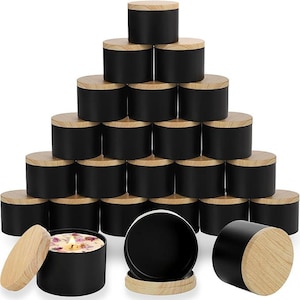 Può includere: Un set di 18 barattoli per candele neri con coperchi in legno. I barattoli sono disposti a forma di piramide. I barattoli sono tutti della stessa dimensione e hanno un design semplice e moderno.